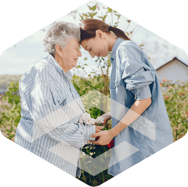 Caregiver embracing an elderly resident in a garden