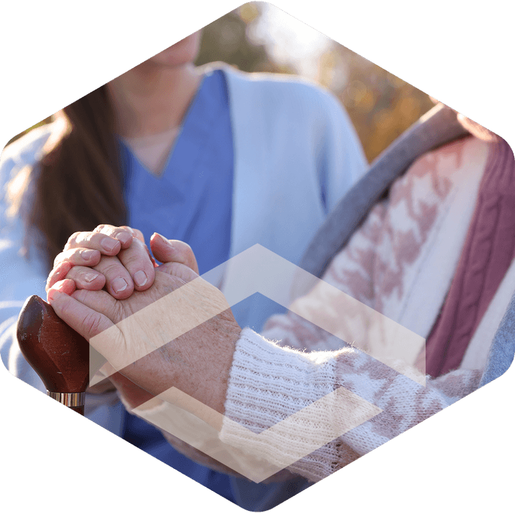 Caregiver holding hands with a memory care resident